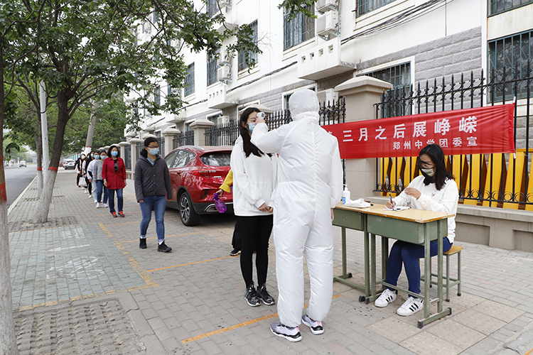 教师模拟学生依次排队，测体温进入校园.JPG