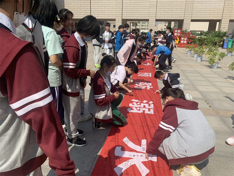 图片2 学生在防溺水宣传横幅上签字1.jpg